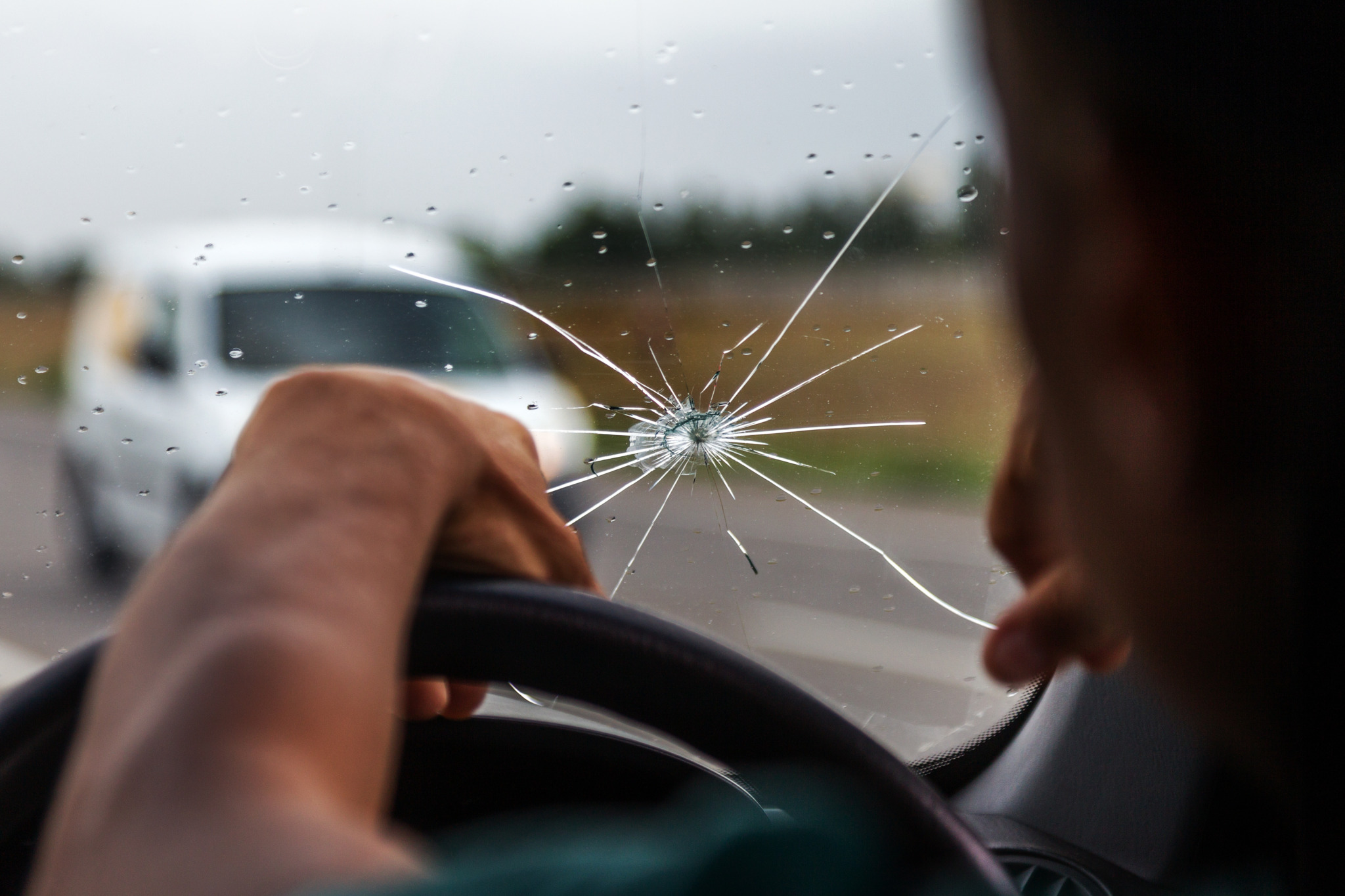 Inside of the car with windshield that was broken in car accident where the walker is injured. Car is on the road. Photo taken with wide lens